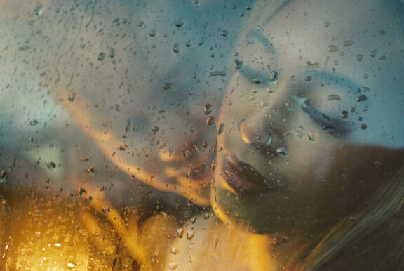 A sexy engagement anniversary portrait with cinematic night lighting taken in a car window in Victoria BC using analog film photography.