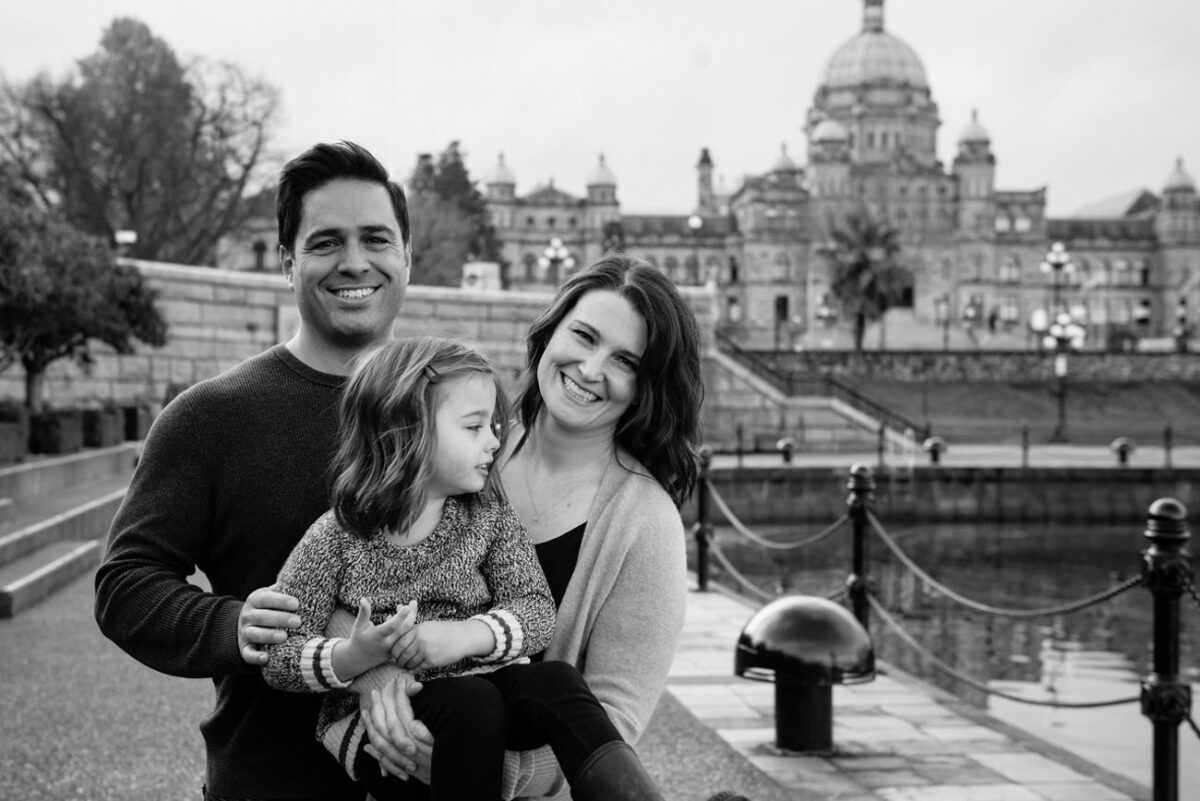 Family portraits at Victoria B.C.'s inner harbour with an adorable five year old. You can see the B.C. Legislature buildings in the distance. It's a great backdrop for a portrait session in Victoria.