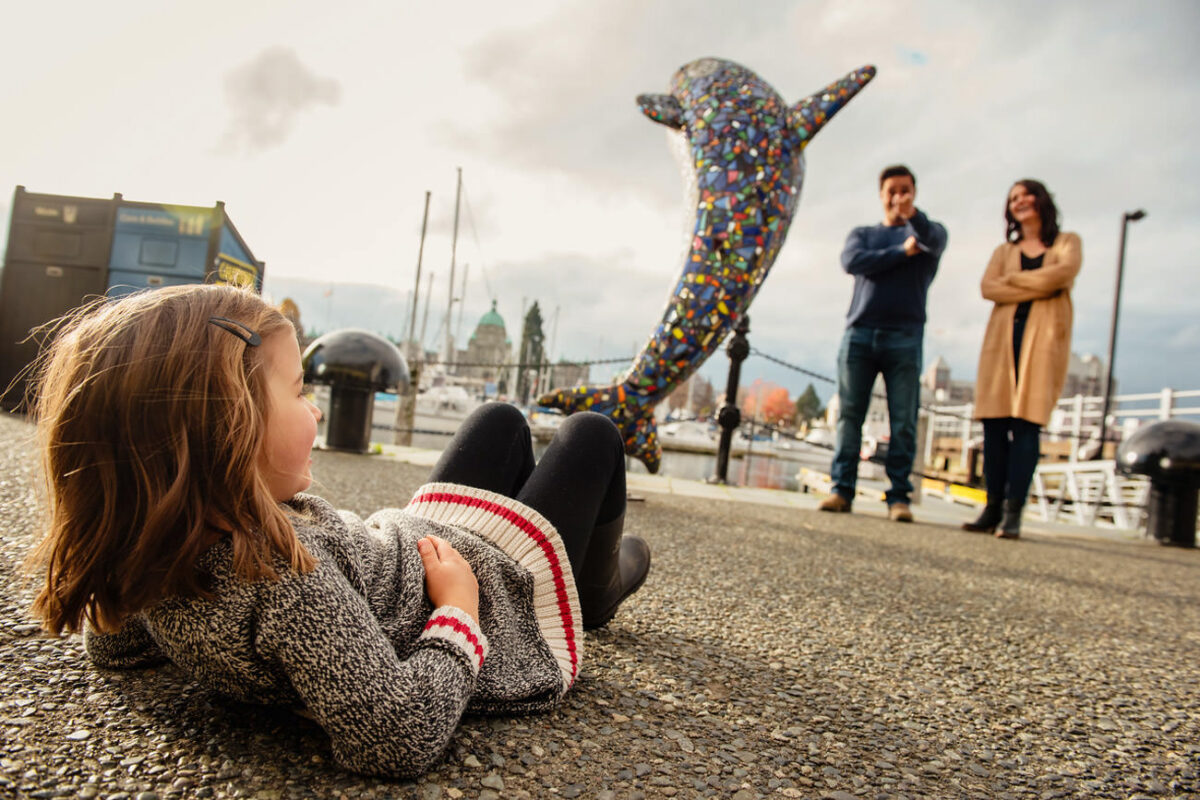 Family portraits at Victoria B.C.'s inner harbour with an adorable five year old. You can see the B.C. Legislature buildings in the distance. It's a great backdrop for a portrait session in Victoria.