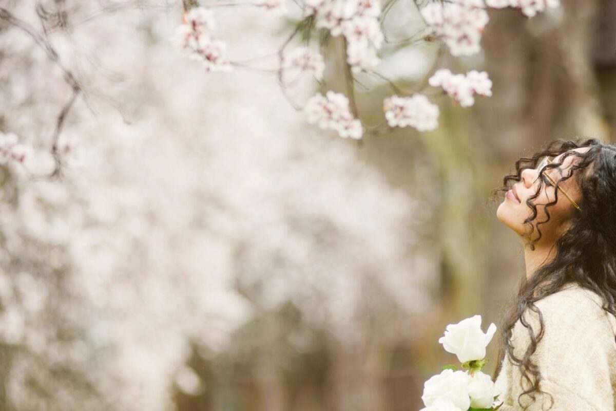 Beauty portrait with a woman in her twenties wearing pink. The portraits were taken at Thunderbird Park in Victoria BC during the spring when the cherry blossoms were blooming. This was a combination of a fashion shoot and a glamour or artistic shoot, with bespoke customized art portraits.