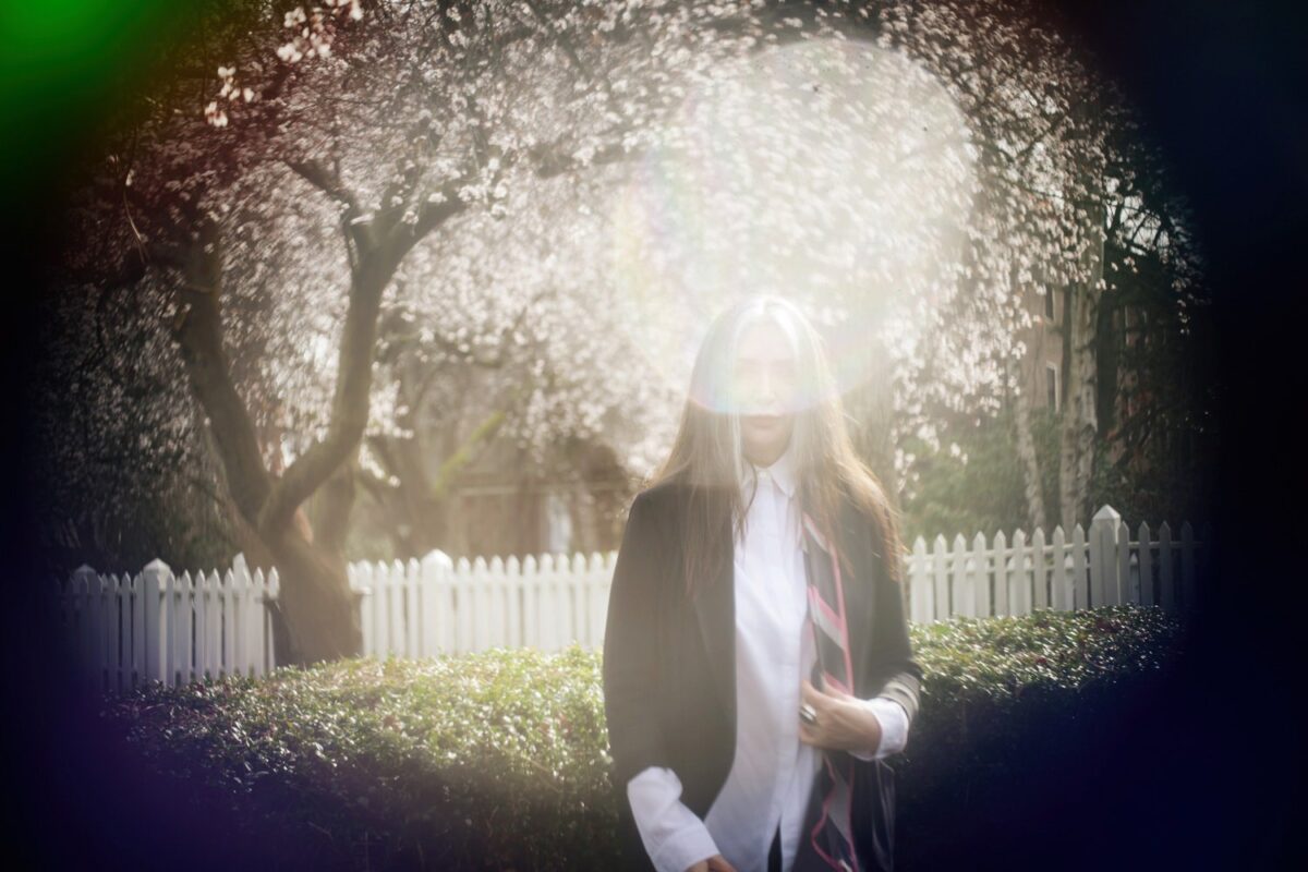 Beauty portrait with a woman over 50 with grey and black hair. The portraits were taken at Thunderbird Park in Victoria BC during the spring when the cherry blossoms were blooming. This was a combination of a fashion shoot and a glamour or artistic shoot, with bespoke customized art portraits.