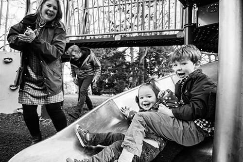 Candid family portrait photograph of a family playing at Beacon Hill Park in Victoria BC