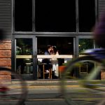 Best creative and artistic wedding portrait in downtown Victoria BC of a couple kissing and two bikes riding by with motion blur