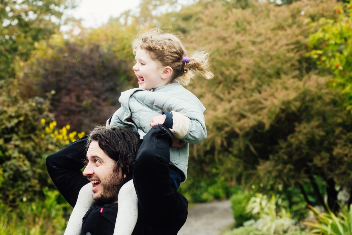 Dad and daughter playing and having fun while being themselves during a portrait session in the autumn