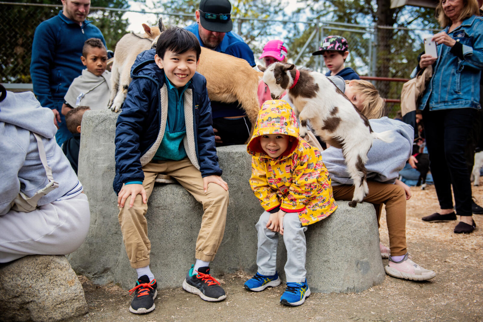 A family portrait of two kids with goats at the Beacon Hill Park petting zoo in Victoria BC