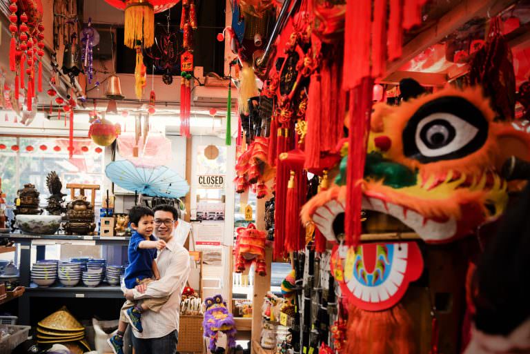 A father and toddler are in a Chinatown shop in Victoria BC exploring while having documentary family photos taken by Christina Craft.