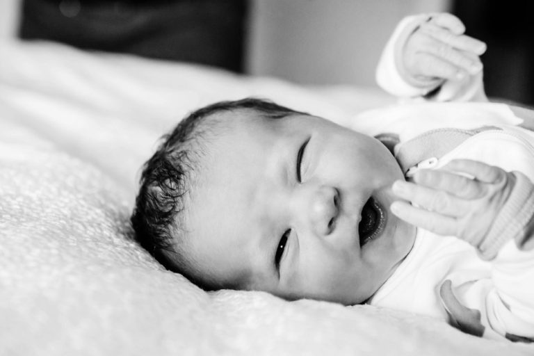 A funny natural and candid photo of a newborn taken in Victoria BC where the baby is making a funny face.