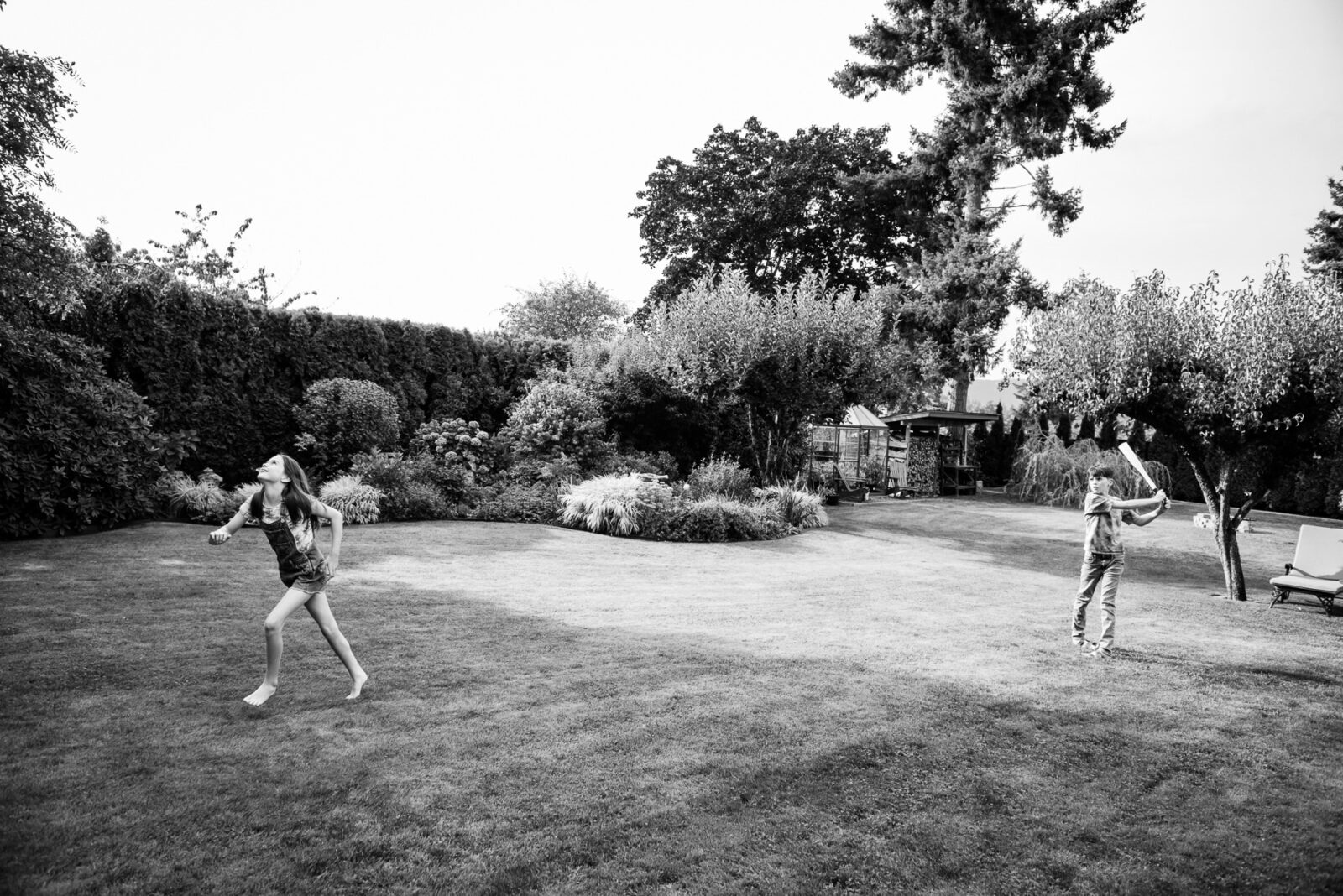 Kids playing baseball in their backyard. this is a candid portrait in Victoria BC