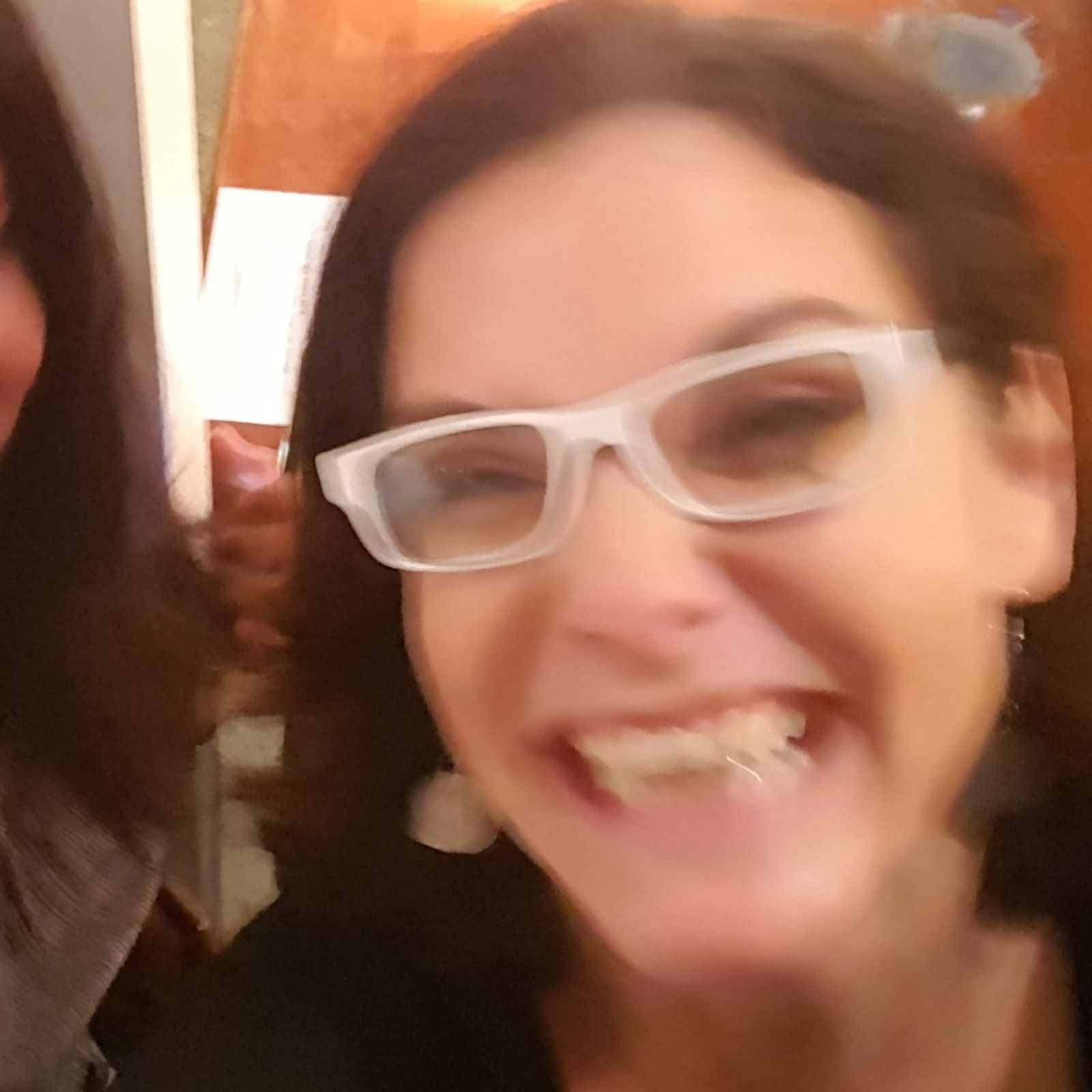 A blurry phone picture of me with white glasses.