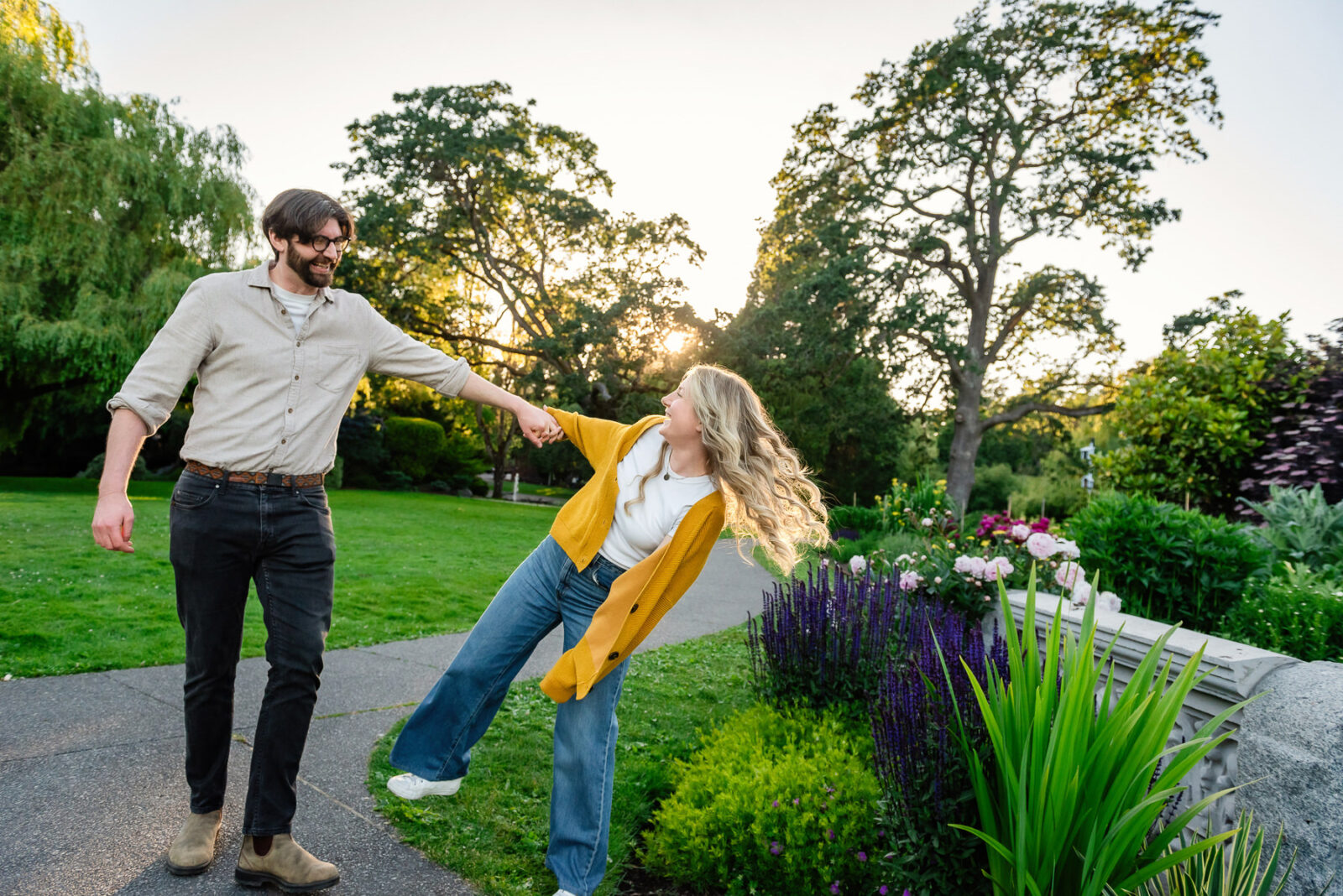 A girl pulls her fiance towards her as they walk in the garden area at Beacon Hill Park.