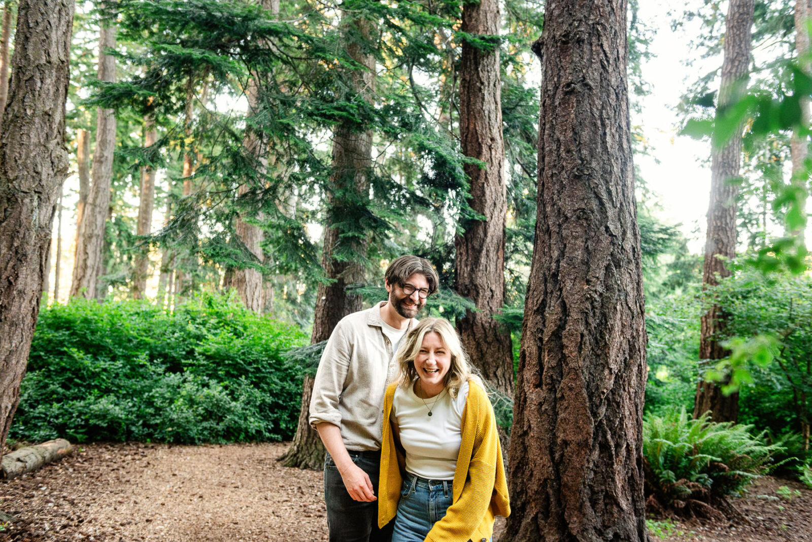A couple walks through the forest in Beacon Hill Park in Victoria BC