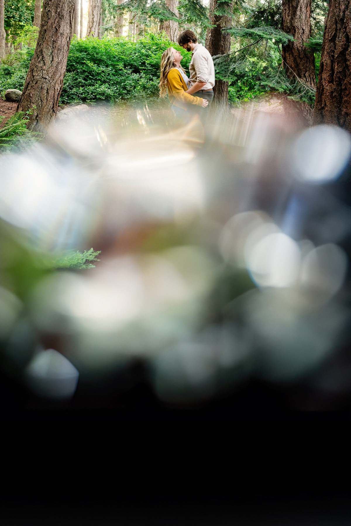 An artistic engagement portrait with bokeh in the front of the lens