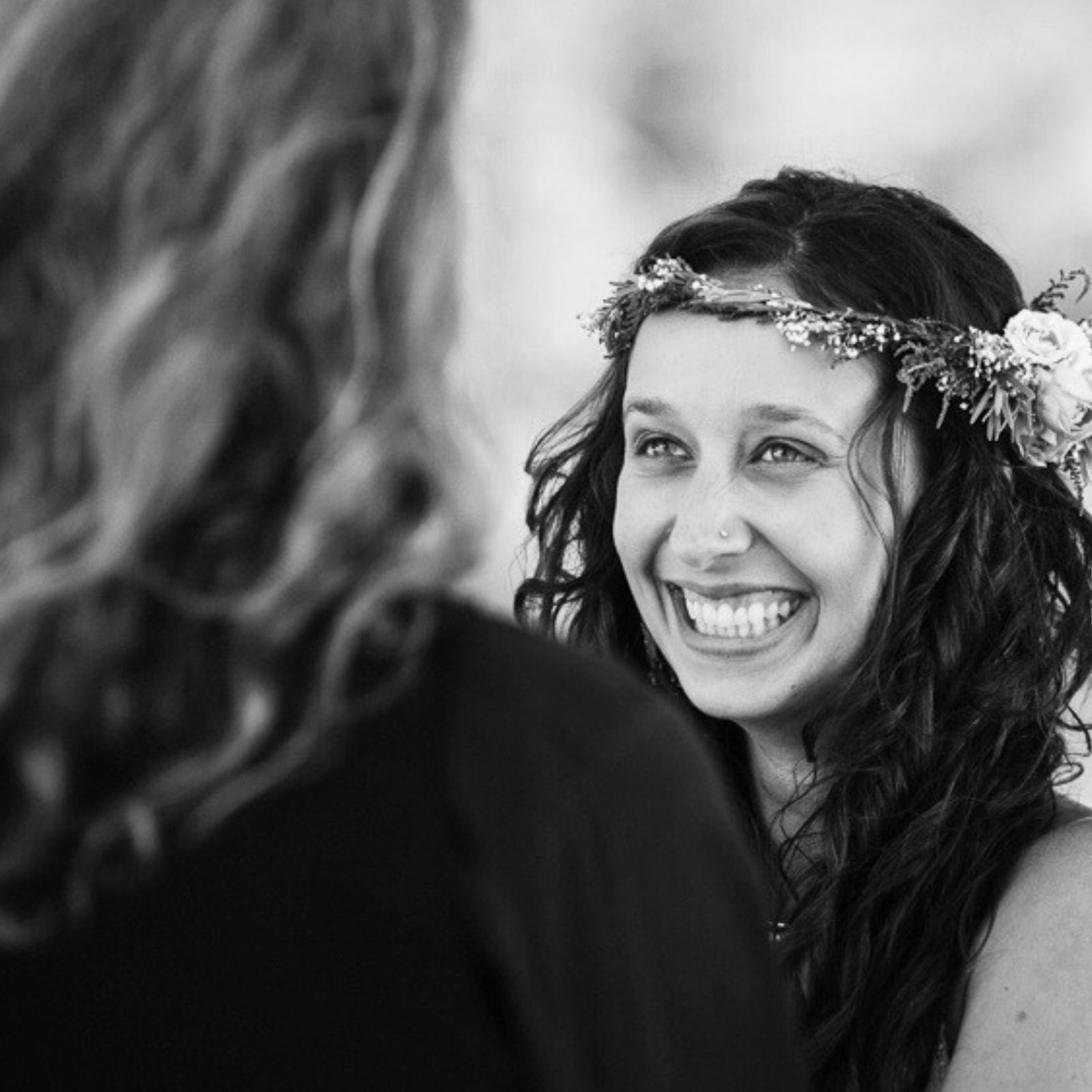 A bride laughs as she says her wedding vows during her ceremony in Victoria BC. The photo is in black and white.