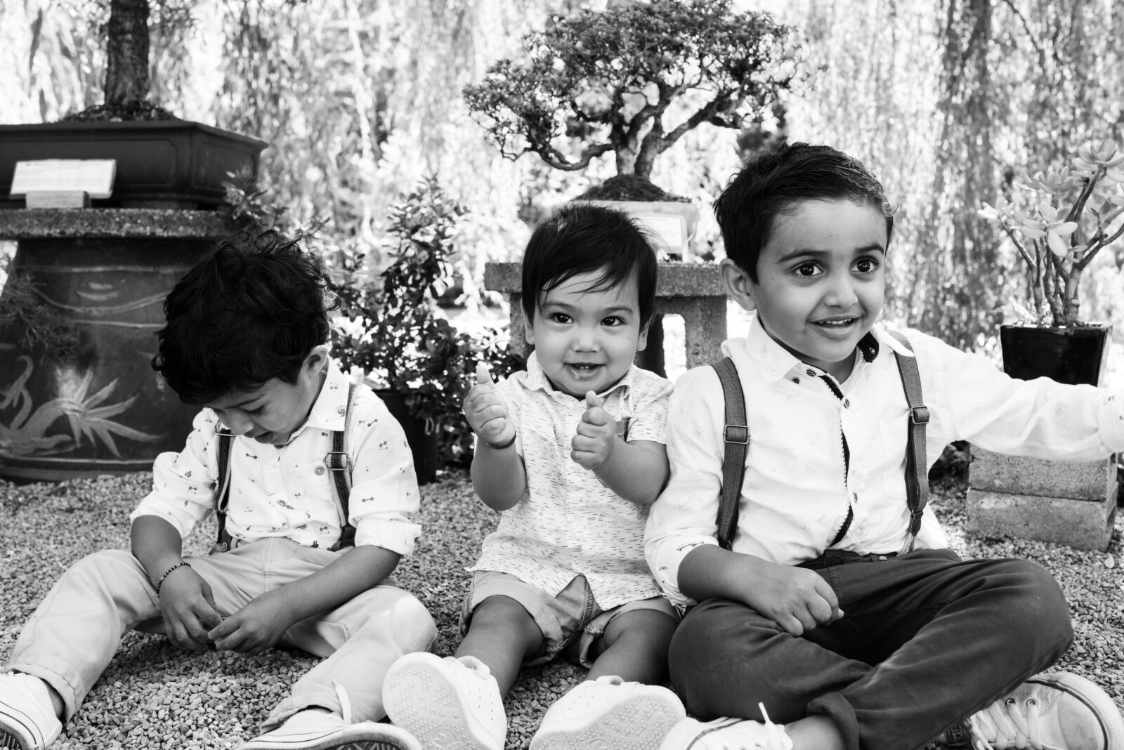 Three toddlers, including a one year old on his birthday, all wearing suspenders and looking in different directions while at a private party documented by photographer Christina Craft at Dr. Sun Yat-Sen Classical Chinese Garden in Vancouver BC