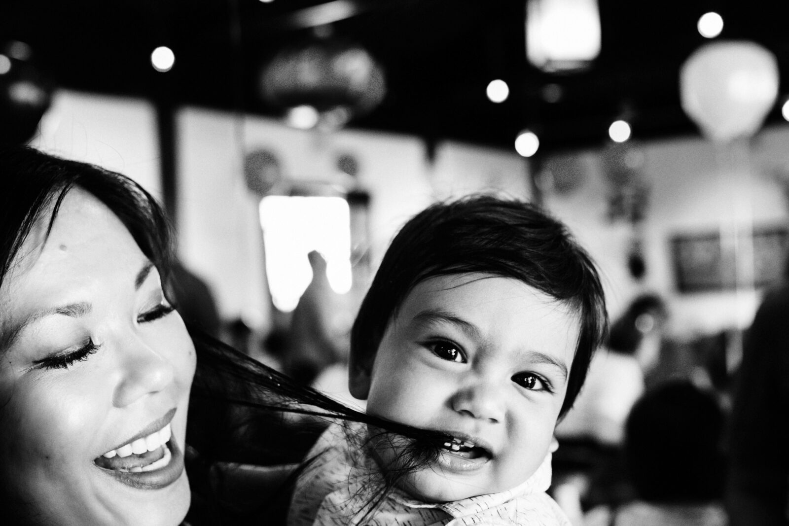 A funny photo of a one year old eating his mom's hair