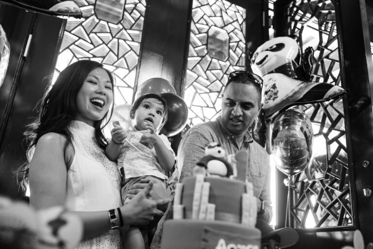 A first birthday party where everyone is singing happy birthday and the cake has candles. It is a black and white documentary Dr. Sun Yat-Sen Classical Chinese Garden in Vancouver BC pphoto