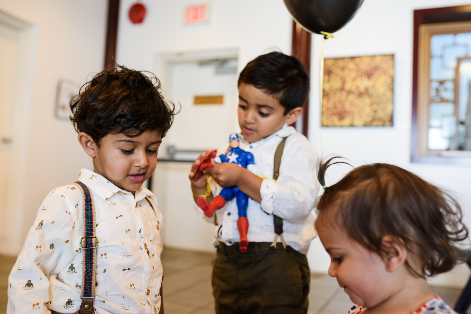 A candid photo of toddlers wearing suspenders at a birthday party at Dr. Sun Yat-Sen Classical Chinese Garden in Vancouver BC