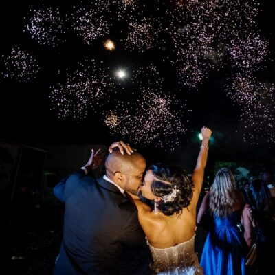 A Victoria BC wedding with fireworks. The couple is kissing and is lit with flash in the foreground.