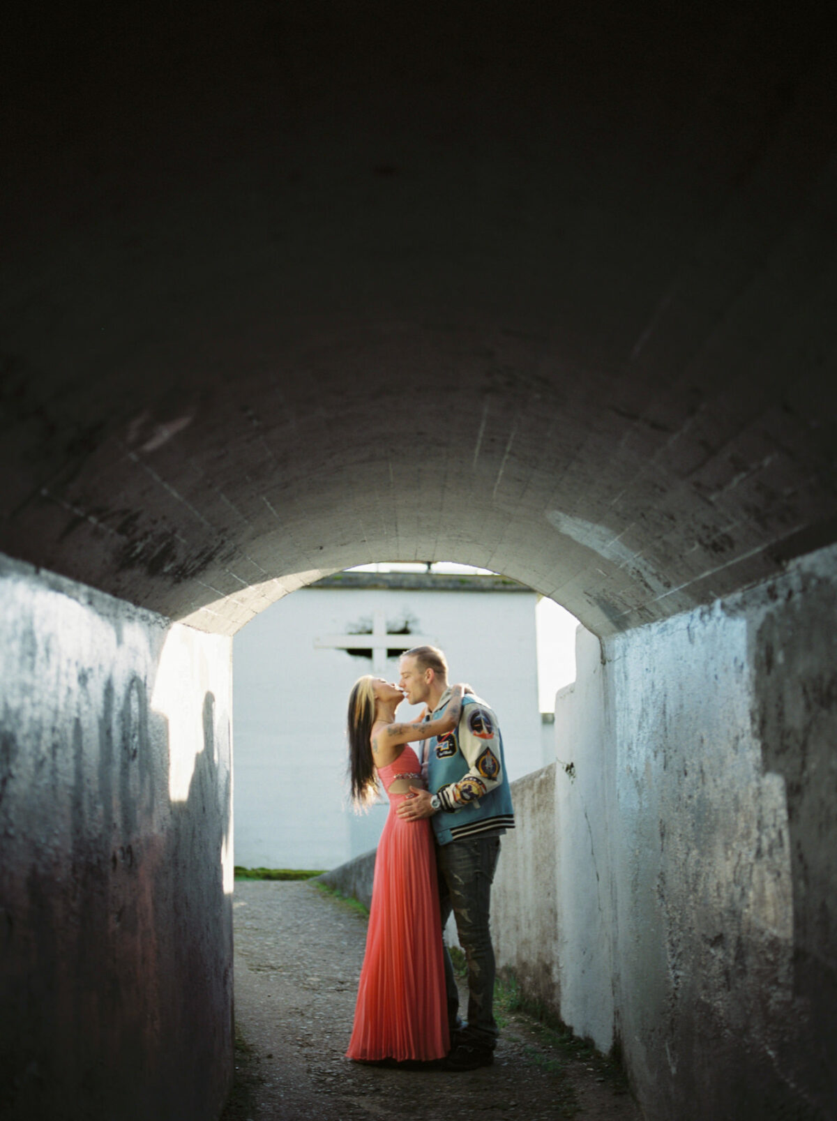 A couple stands kissing in a tunnel in Victoria BC. 