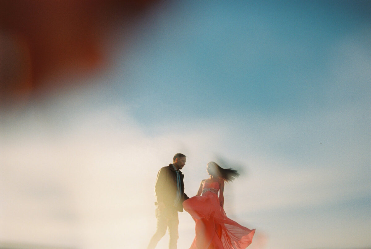An abstract creative couples portrait of two people dancing with the sky above them blurry using a trick special effects filter. 
