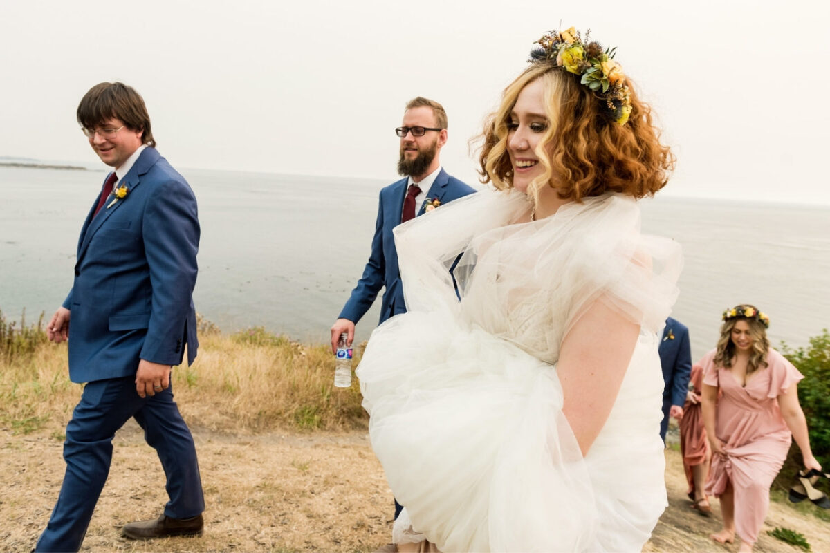 Bridal party walking at the back of beacon hill park in Victoria at the grassy area along the hill