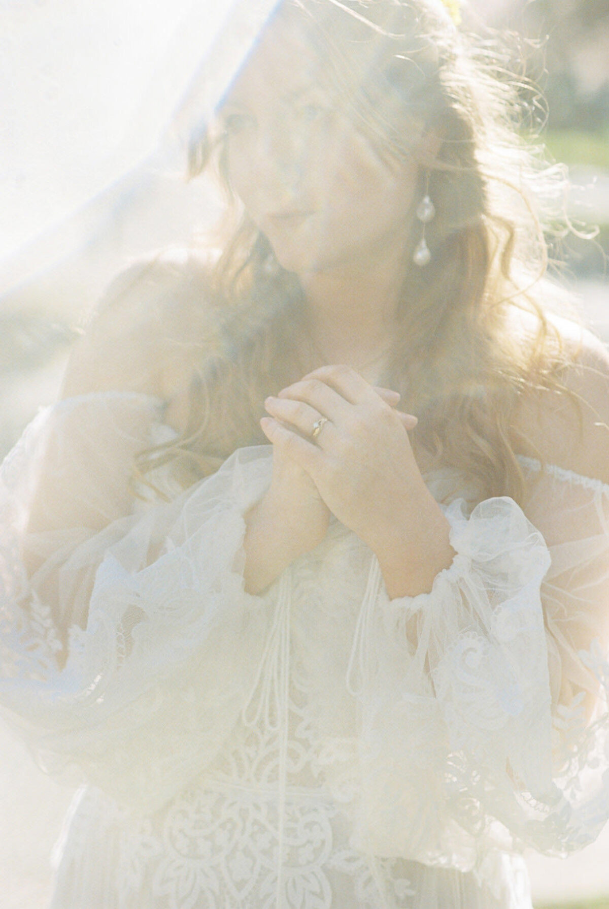 A bohemian wedding dress detail of tassels and a ring photographed on film at Uvic in Victoria BC. 