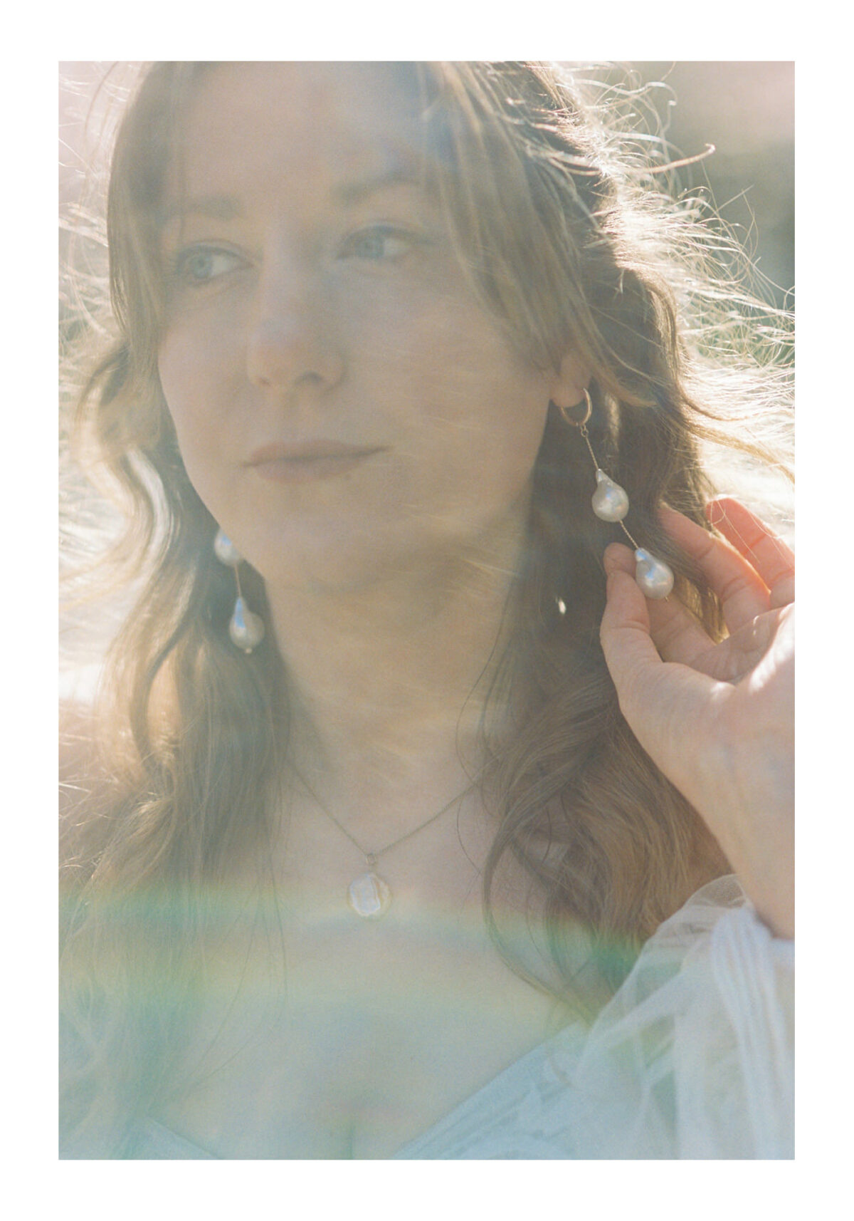 An editorial wedding photo of a bride showing her earing details during a boho styled shoot at Uvic in Victoria BC. 