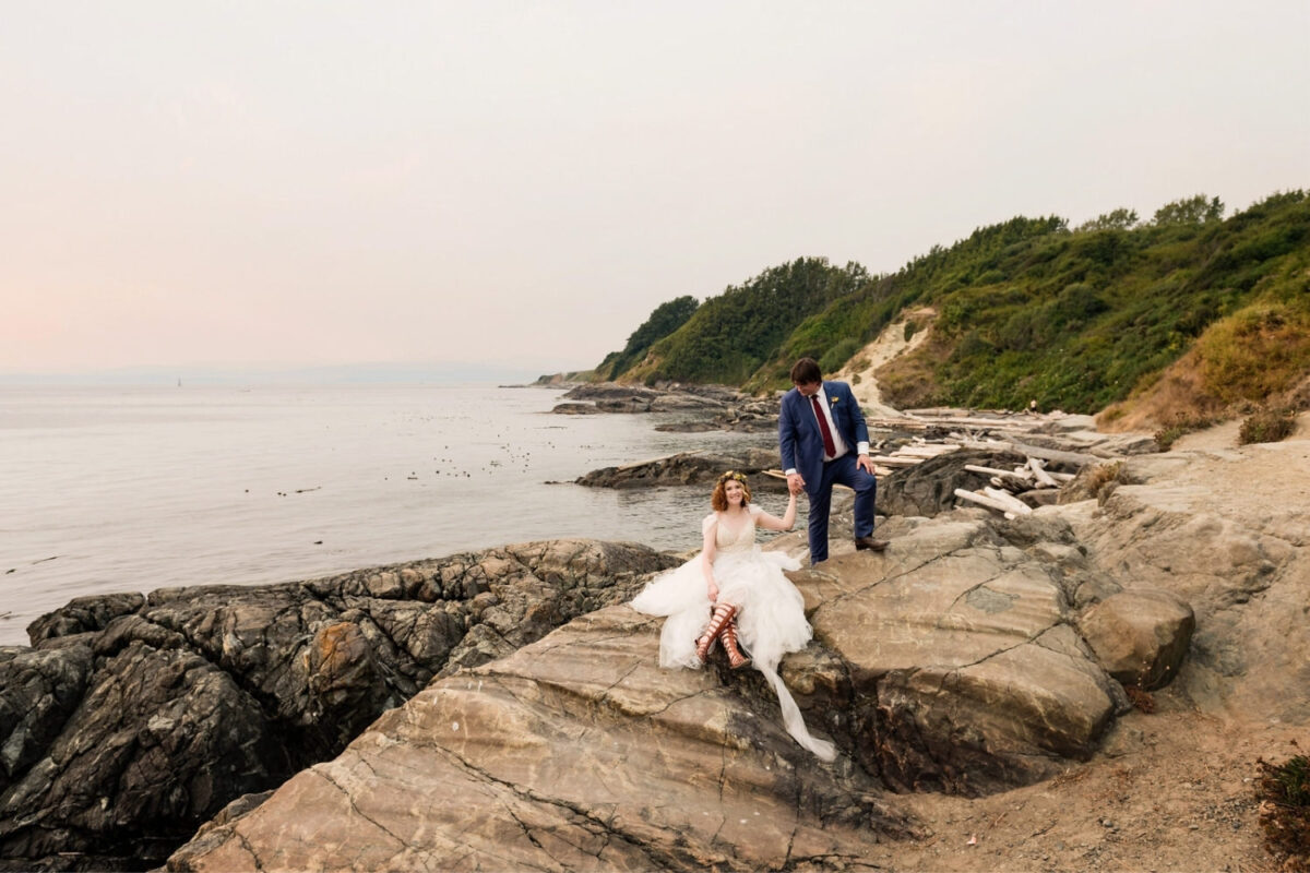 Victoria BC wedding portrait with bride sitting with her boho wedding dress and a groom holding her hand