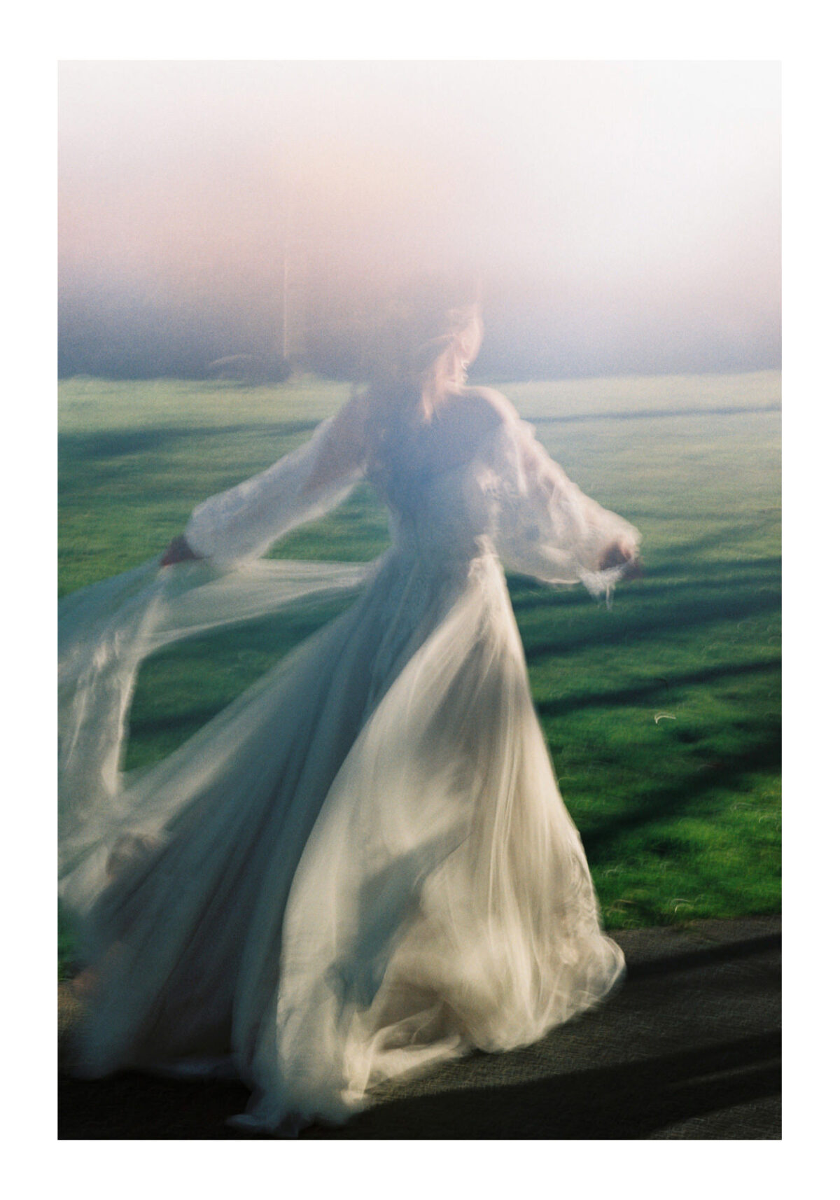 A light leak photo taken with Kodak Gold 120mm film of a bride moving with motion blur in her persephone gown by watters designs during a fashion shoot at Uvic in Victoria BC
