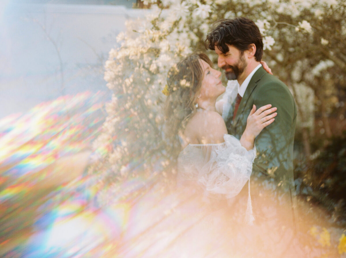 A creative impressionism photo on film of a bride and groom with reflections overlaid on them. 