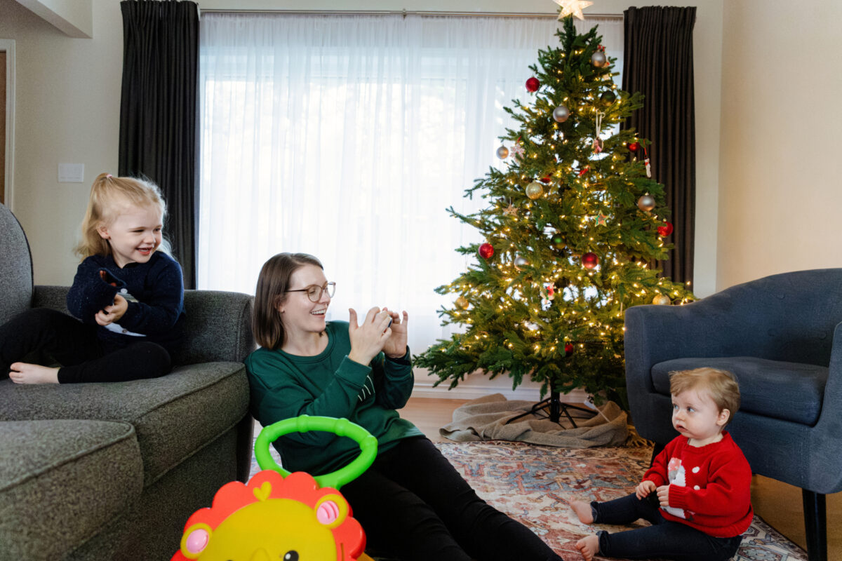 A Christmas documentary photography session with two children and their mom by the Christmas tree in Victoria