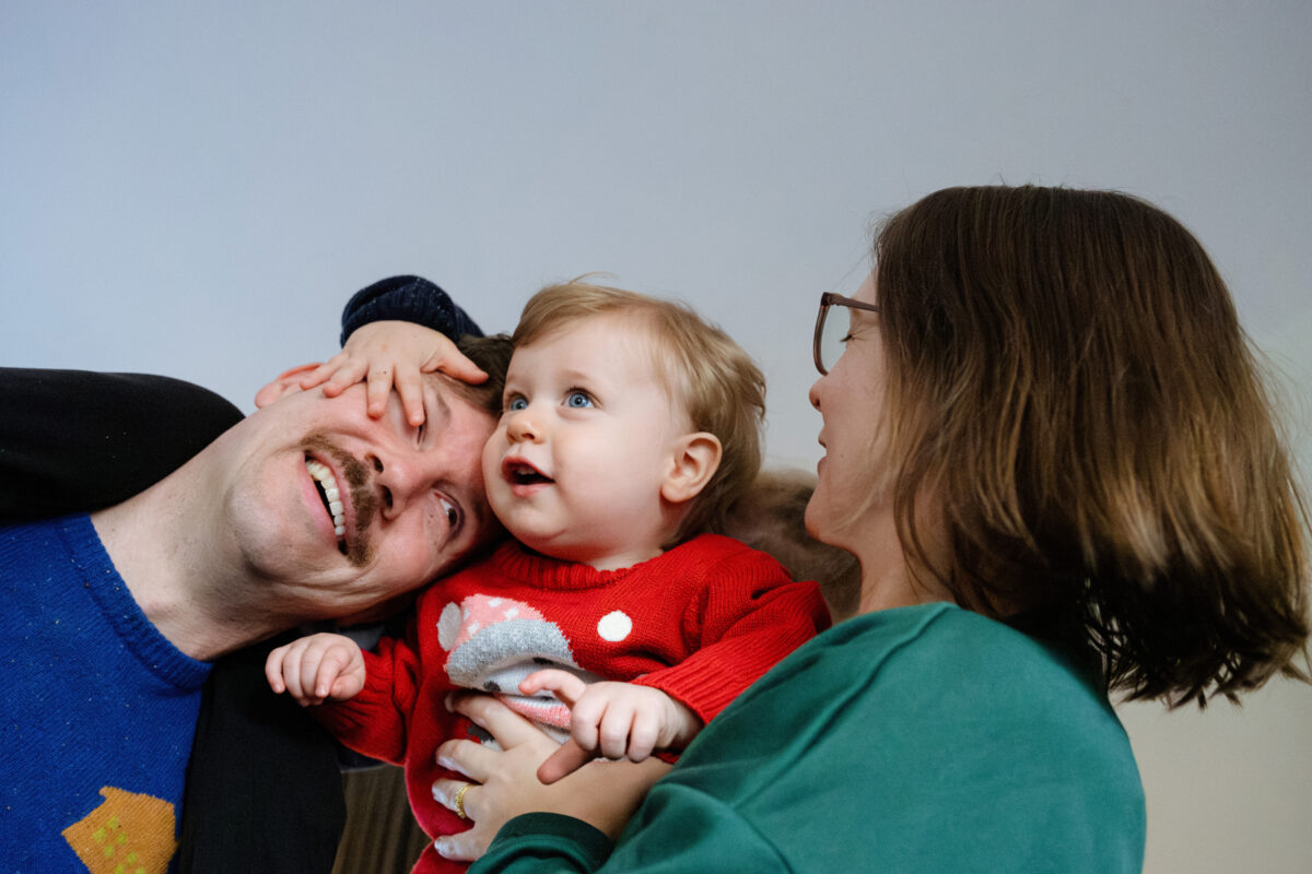 A cute picture of a family cuddling on the couch during their Christmas mini session in Victoria BC. 