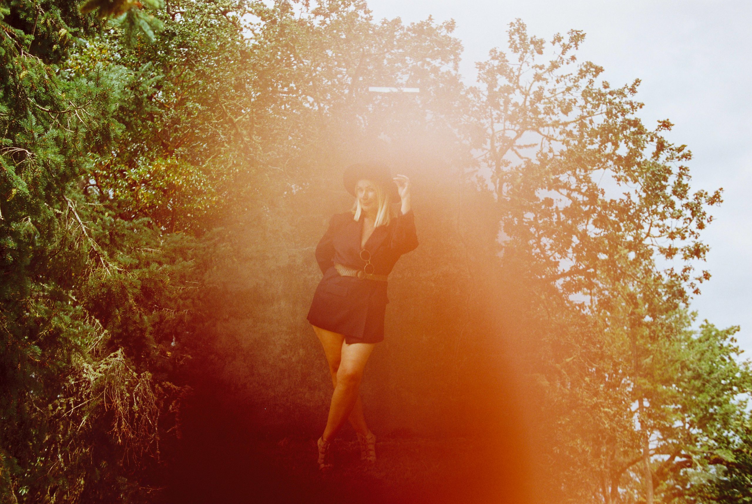 An analog creative surreal abstract film photo taken on Cinestill film of a fashion model at Fort Rod Hill in Victoria BC