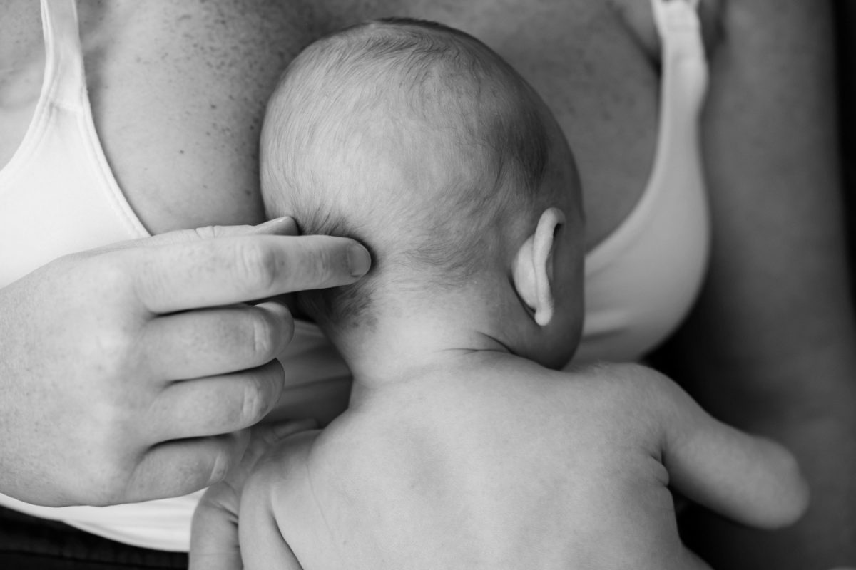 A touching moment between mother and newborn baby in black and white, taken during an at-home baby portrait session in langford BC