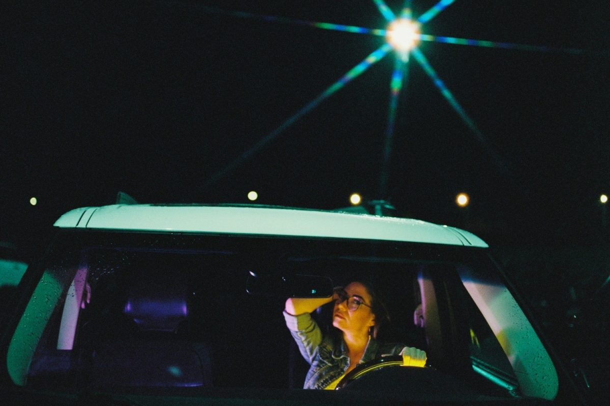 A cinematic portrait of a woman in a car illuminated by ambient and video lights using Cinestill 800T 120 medium format film. The image was taken in a parking lot at Fisherman's Wharf in Victoria BC and the street light looks like a star because of a filter I used on the lens.