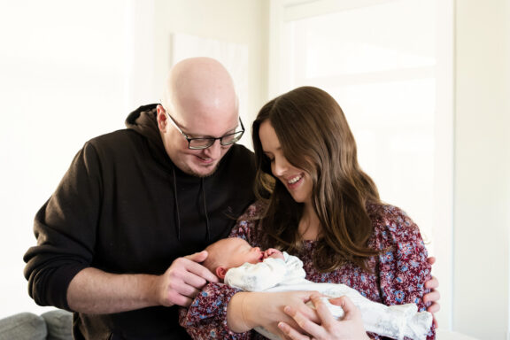 Victoria BC lifestyle newborn portrait of parents holding their baby in their home.