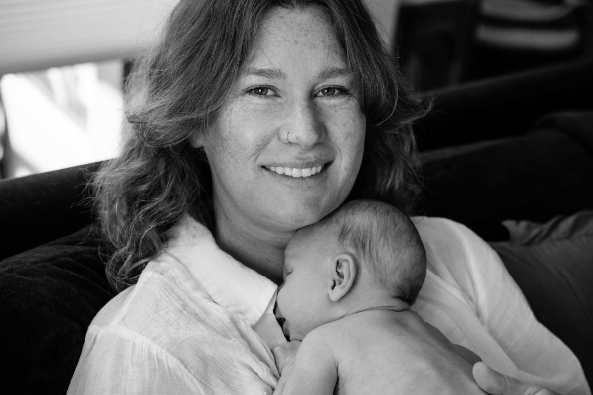 A new mom in Langford BC holds her newborn baby during an at-home baby session near Victoria. 