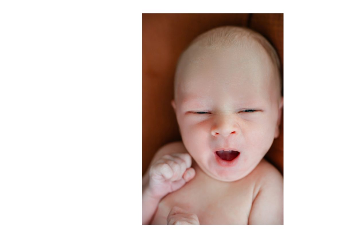 A colour cute newborn portrait with baby making a funny face , taken at home in Langford BC