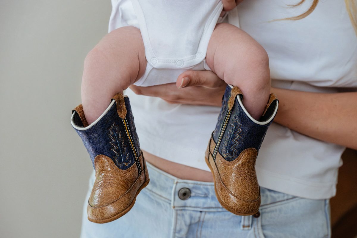 A baby wearing cowboy boots during a victoria bc newborn session.