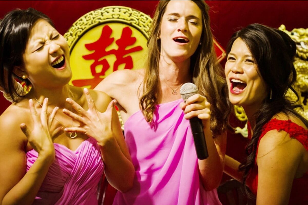 A Chinese wedding banquet wedding in Victoria BC with a bride in a red dress singing with her bridesmaids