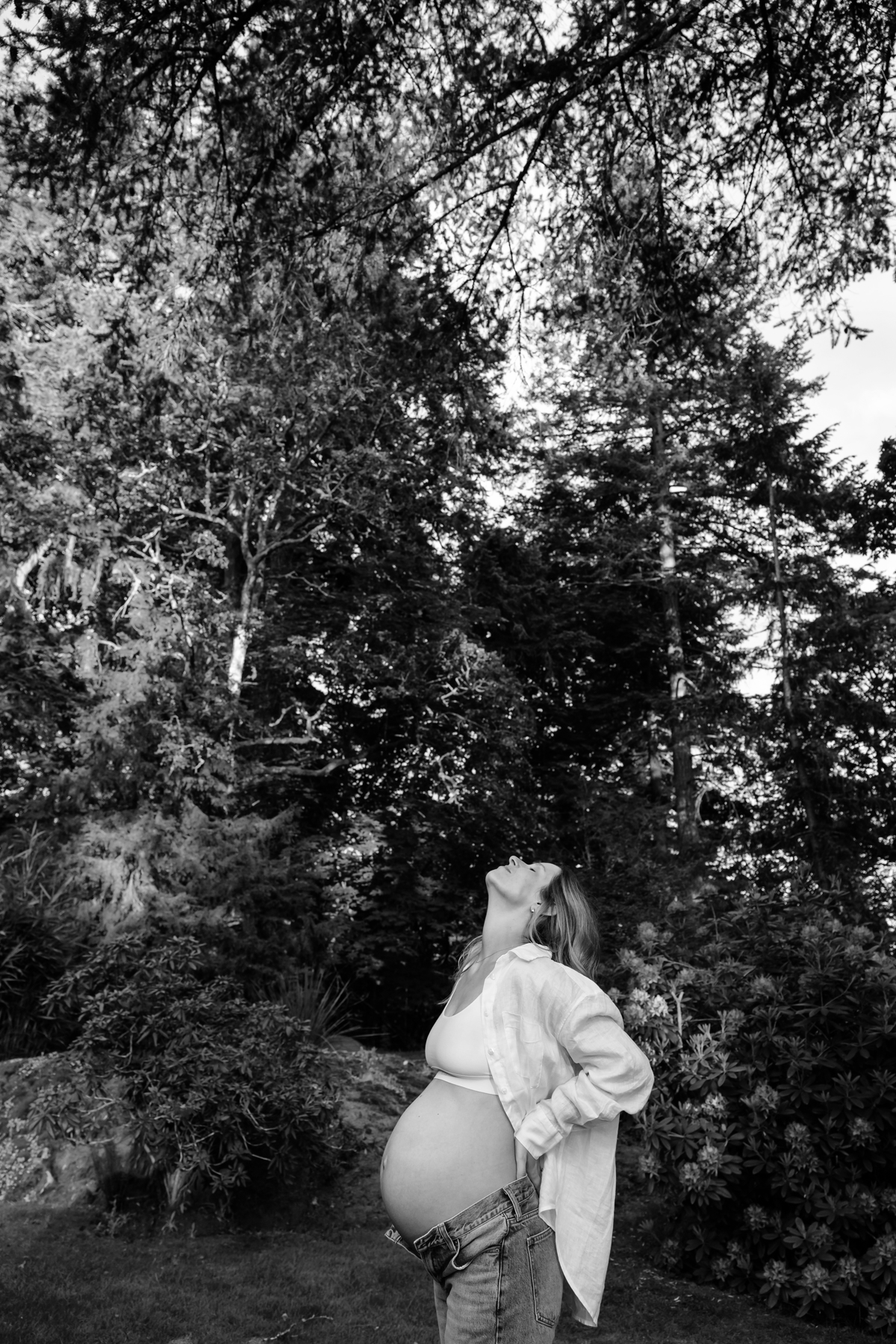 A black and white timeless editorial maternity portrait in Victoria British Columbia surrounded by garden and forest.
