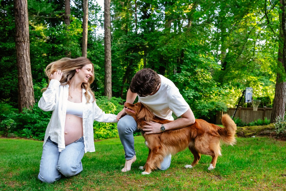 Victoria BC maternity portrait of a couple playing in the backyard at home with their dog